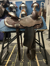 Load image into Gallery viewer, Saddle on a stand with a blue background featuring other saddles.

