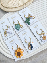 Load image into Gallery viewer, Clay by Day Designs - Polymer Clay Keychains - Puffin, Boho, Sunflower, Skull: Daisy-Clay by Day Designs-Evolution Equestrian Co.
