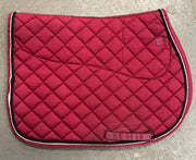 Red quilted saddle pad on a gray surface