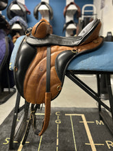 Load image into Gallery viewer, Brown leather saddle on a blue chair with a blurred indoor background
