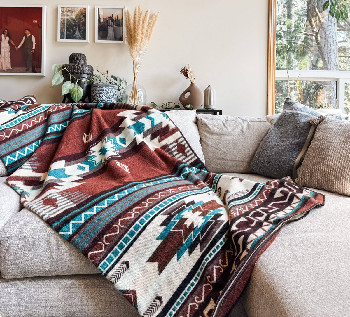 Decorative blanket with geometric pattern draped over a sofa in a living room.