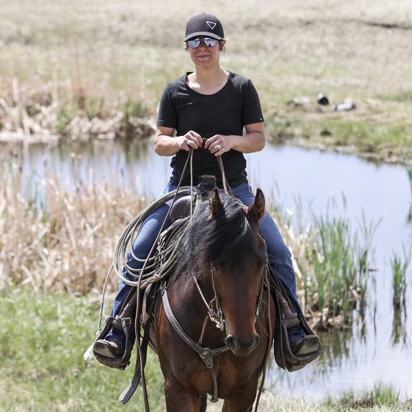 Person riding a horse by a body of water